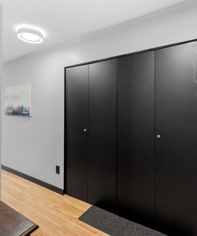 Spacious entrance featuring sleek black cabinetry and natural wood flooring, perfect for welcoming guests.