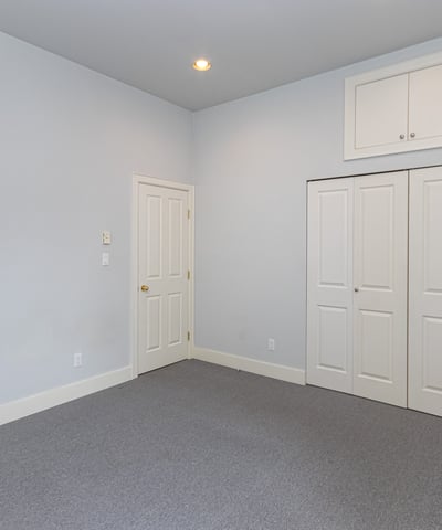 Spacious room with ample natural light, featuring dual closets and a versatile layout for various uses.