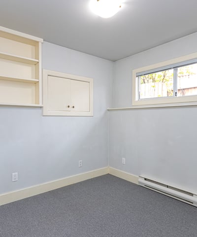 Bright, versatile room with built-in shelving, offering potential for a home office or creative space.