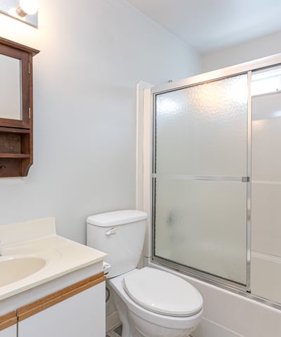 This well-equipped bathroom features a sleek shower enclosure and convenient storage space, perfect for everyday use.