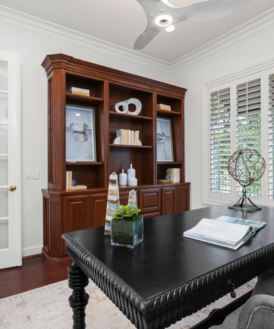 Home office featuring built-in shelving, large windows, and modern lighting for productivity.