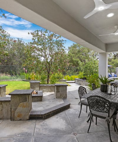 Spacious outdoor patio features a built-in firepit, ceiling fans and lighting perfect for gatherings and enjoying nature.