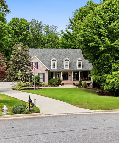 Beautifully landscaped home nestled on a quiet cul-de-sac, surrounded by mature trees and vibrant foliage.
