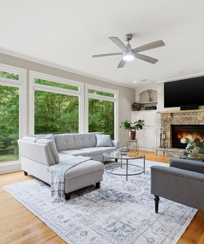 Bright and inviting living room featuring large windows, cozy fireplace, and spacious layout for entertaining.