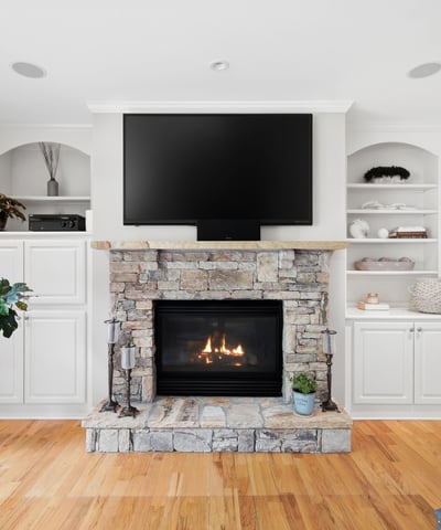 Cozy living space featuring a stone fireplace and built-in shelving, perfect for relaxation and entertainment.