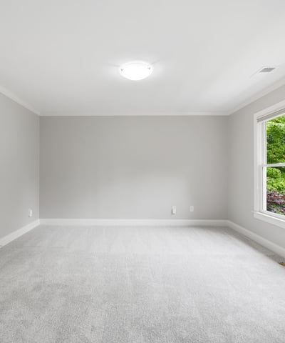 Spacious room with large windows offering natural light, perfect for customization and personal touches.
