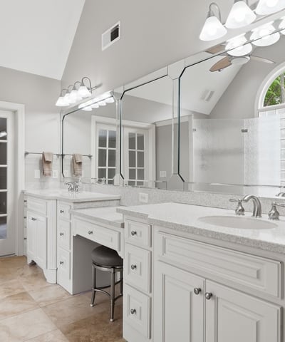 Spacious bathroom featuring dual vanities, abundant natural light, and access to a private outdoor space.
