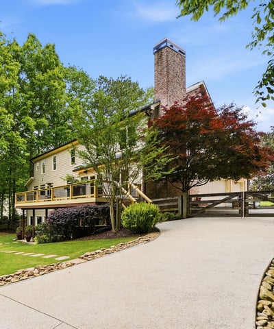 Discover a beautifully landscaped property featuring ample outdoor space and a welcoming driveway leading to the entrance.