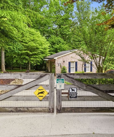 Nestled amid lush greenery, this property features a welcoming entrance and ample outdoor space for relaxation.