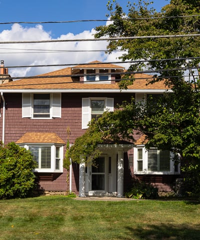 Spacious home featuring a well-maintained lawn, mature trees, and a welcoming entrance, perfect for family living.