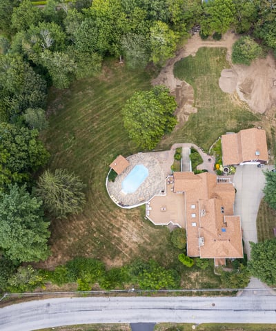 Spacious property featuring a pool, expansive lawn, and potential for development in a quiet neighborhood.
