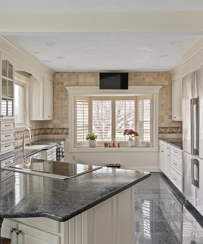 This modern kitchen features sleek cabinetry, granite countertops, and ample natural light for a functional workspace.