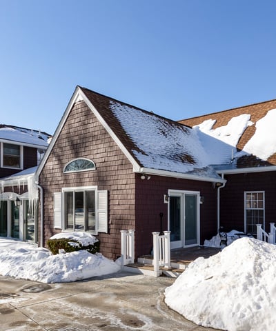 Spacious multi-level home featuring ample parking, surrounded by winter scenery, perfect for year-round living.
