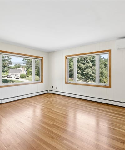 Bright and spacious living area featuring large windows and hardwood floors, perfect for relaxation and gatherings.