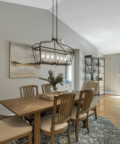 Bright dining area featuring a modern light fixture, perfect for intimate gatherings and open to lush views.