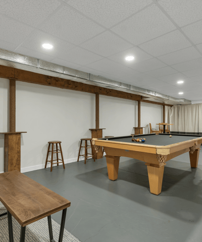 Spacious basement leisure area featuring a pool table, bar seating, and ample room for entertainment.