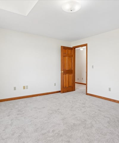 Spacious, versatile room with neutral tones, ample natural light, and convenient access to adjacent areas.