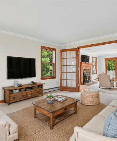 Spacious living room featuring large windows, a cozy fireplace, and a seamless flow to outdoor views.