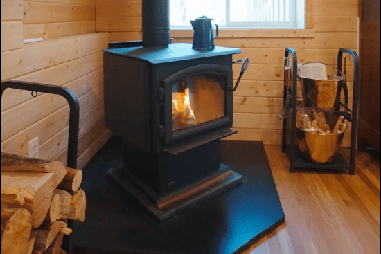 16 of 61. Cozy wood-burning stove enhances warmth and comfort in this inviting cabin space, perfect for gatherings.