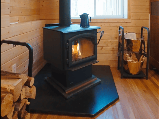 16 of 61. Cozy wood-burning stove enhances warmth and comfort in this inviting cabin space, perfect for gatherings.