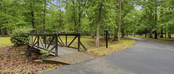 Welcome to a tranquil wooded retreat, featuring a picturesque bridge.