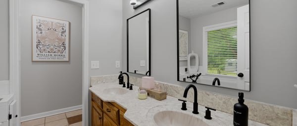 Modern bathroom featuring dual sinks, sleek fixtures, and a spacious layout with ample natural light.
