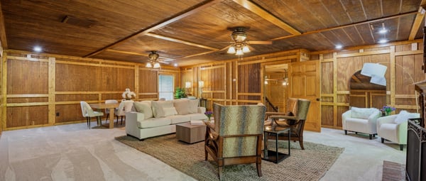 This spacious living area features warm wood accents, plush carpeting, and ample natural light for relaxation.