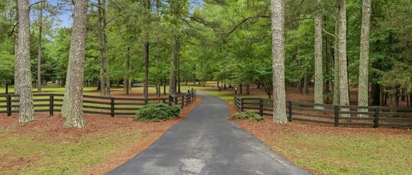 Discover a spacious property nestled in a lush, wooded setting with a welcoming private driveway.