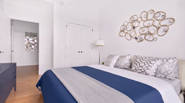 Bright bedroom featuring modern decor, plush bedding, and a unique wall art element for added character.