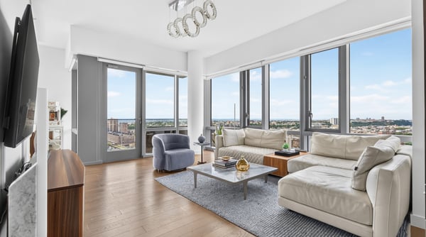 Bright and airy living space with expansive windows offering stunning city views and modern design touches.