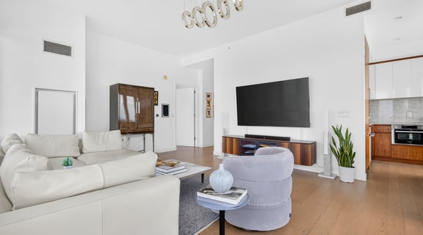 Bright open-concept living area features modern furnishings and ample natural light, perfect for relaxation and entertaining.