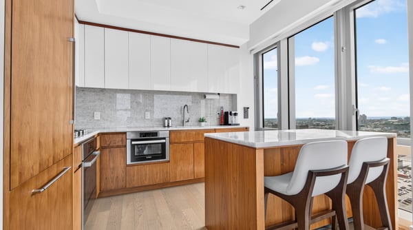 This modern kitchen features sleek cabinetry, ample counter space, and panoramic views through large windows.