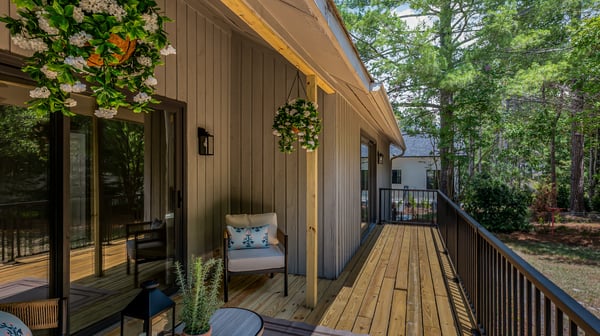 Discover a spacious outdoor deck perfect for relaxation, adorned with greenery and surrounded by nature.