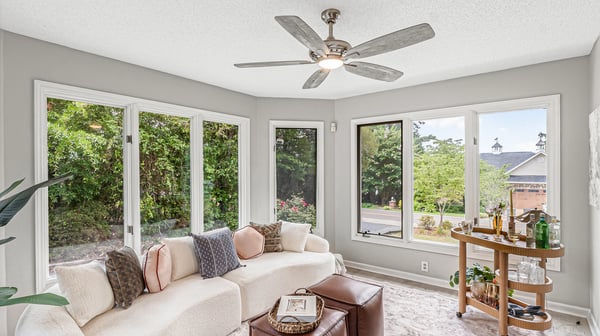Bright sunlit space featuring expansive windows, perfect for relaxation and enjoying the surrounding greenery.