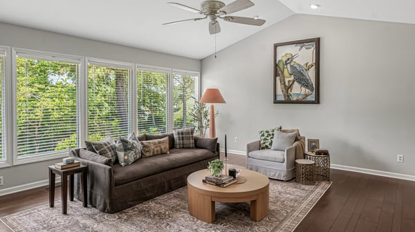 Bright and airy living space with large windows, showcasing views of nature and modern furnishings.
