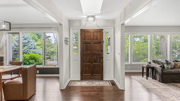 Bright and inviting foyer leads to a spacious living area with abundant natural light and outdoor views.