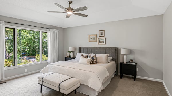 Bright, spacious bedroom featuring a cozy ambiance, large windows for natural light, and modern furnishings.