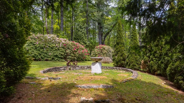 Discover a private backyard oasis surrounded by lush greenery and vibrant floral displays, perfect for relaxation.