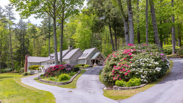 Nestled among lush greenery, this stunning property features expansive gardens and a winding driveway for added privacy.