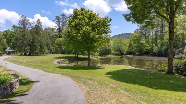 Spacious lot with scenic pond views, lush greenery, and well-maintained pathways, perfect for outdoor activities.