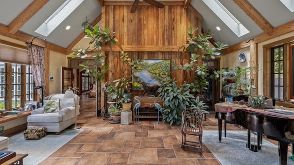 Spacious living area featuring natural light, high ceilings, and abundant greenery for a cozy atmosphere.