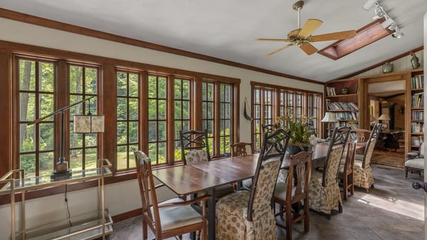 Bright sunroom with expansive windows, perfect for dining and enjoying garden views year-round.