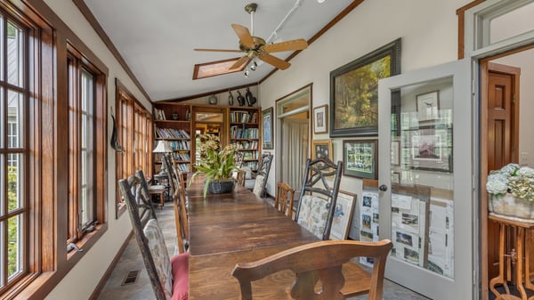 Bright and inviting dining area features ample natural light, a spacious table, and built-in bookshelves.