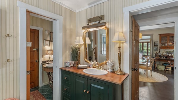 This inviting bathroom features a vintage sink and warm lighting, seamlessly connecting to adjoining living spaces.