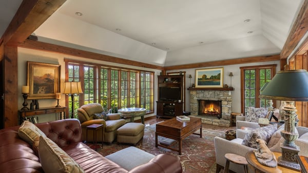 Spacious living area with a warm fireplace, abundant natural light, and inviting outdoor views.