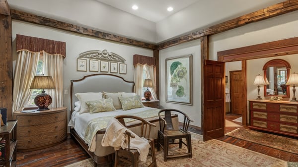 Bright and inviting bedroom featuring warm wood accents and an adjoining vanity area for convenience.