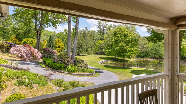 Enjoy picturesque views from the porch, featuring lush gardens and a tranquil pond in a private setting.