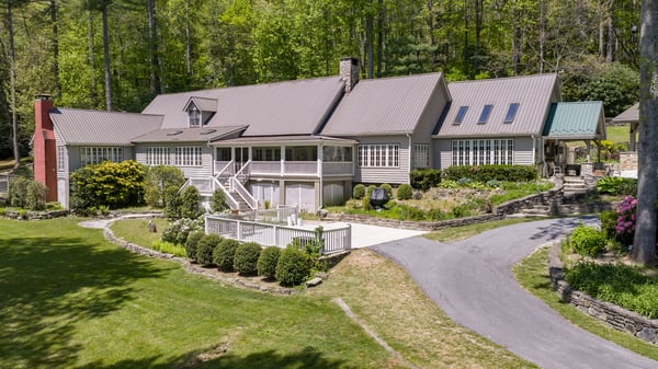 Spacious home surrounded by lush greenery, featuring ample outdoor space and unique architectural design.