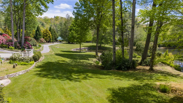 Spacious grounds feature lush greenery and a tranquil pond, perfect for outdoor gatherings and relaxation.