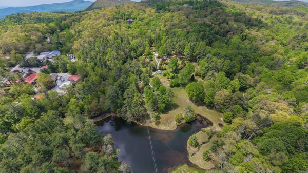 Discover a picturesque property featuring lush landscapes, a peaceful pond, and stunning mountain views.